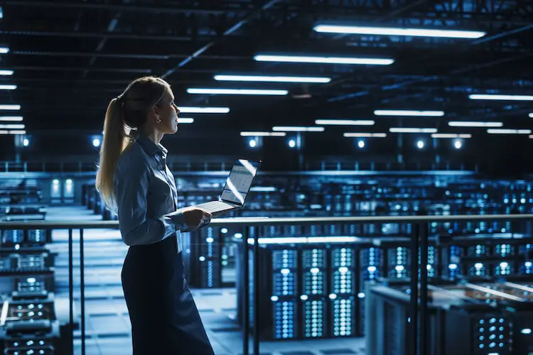 IT Professional Woman Walking Through Room of IBM i Servers