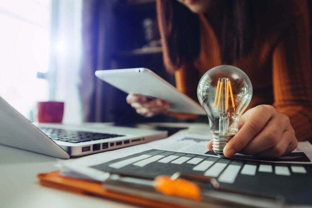 Woman holding light bulb while working